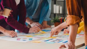 Equipo colaborando en mesa con gráficos y post-its