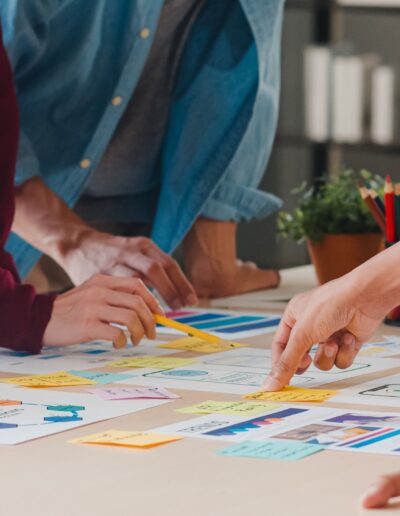 Equipo colaborando en mesa con gráficos y post-its